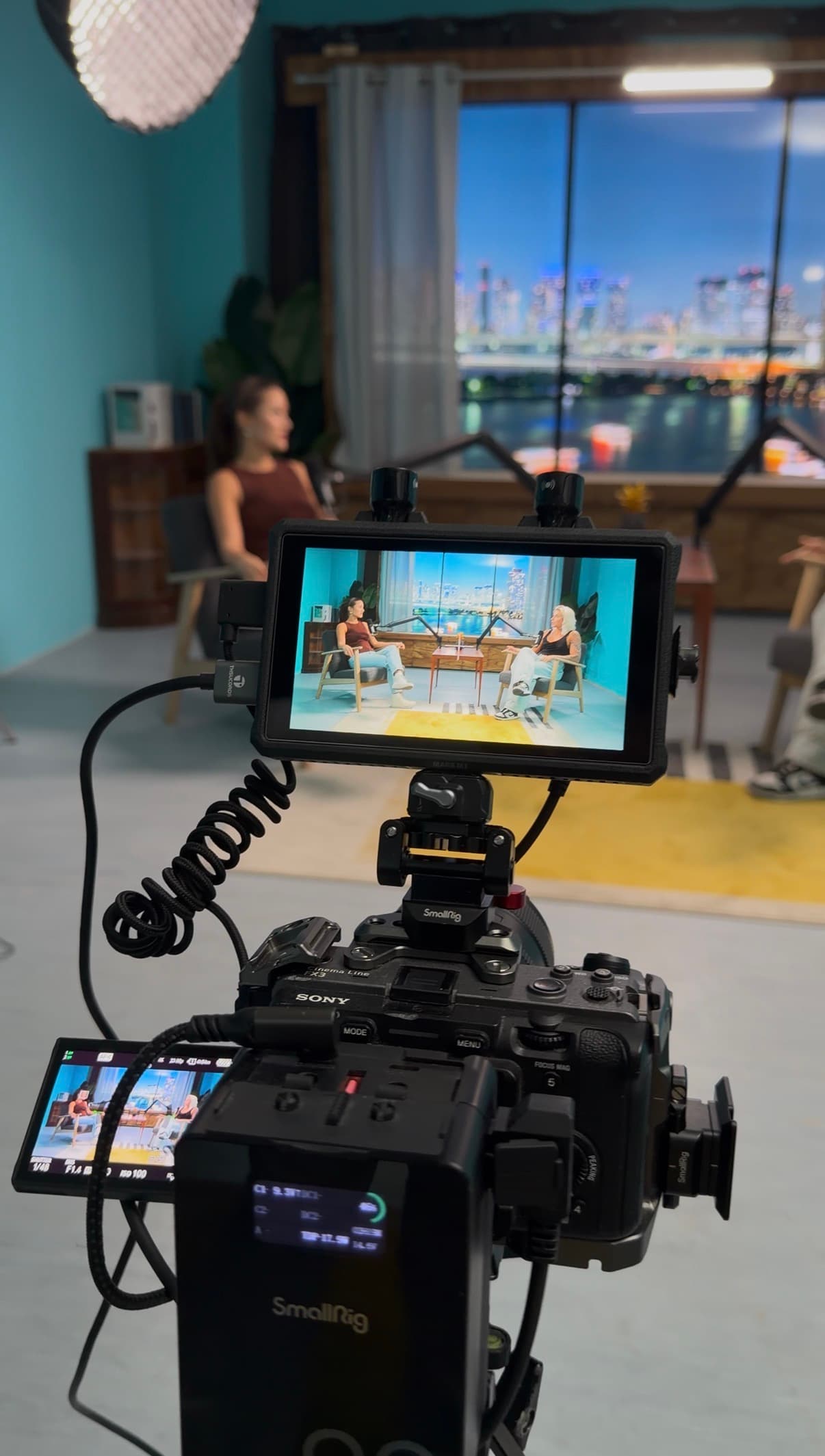 Behind the scenes - Sony cinema camera capturing podcast interview at Film Buro Lisbon with city skyline on Infinite Digital Window